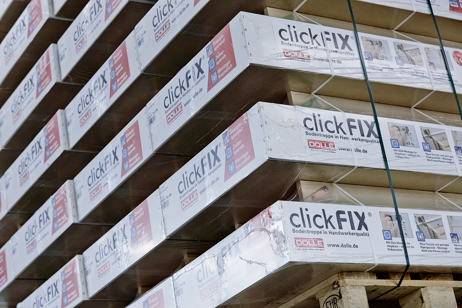 Paquets empilés de systèmes d'escamotables ClickFIX sur une palette, emballés dans des emballages de marque avec des détails du produit.